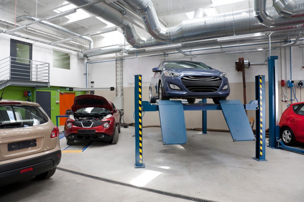 Cars in a large repair workshop or garage.