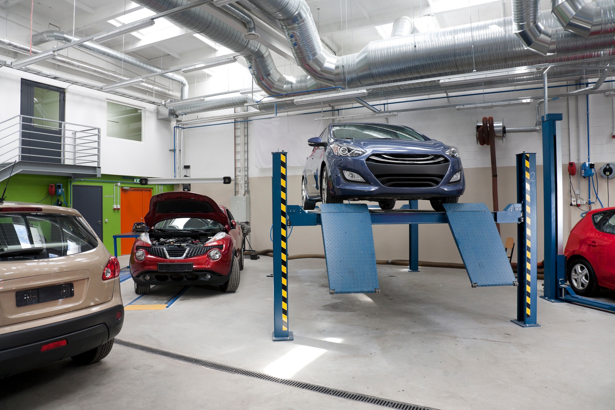 Cars in a large repair workshop or garage.