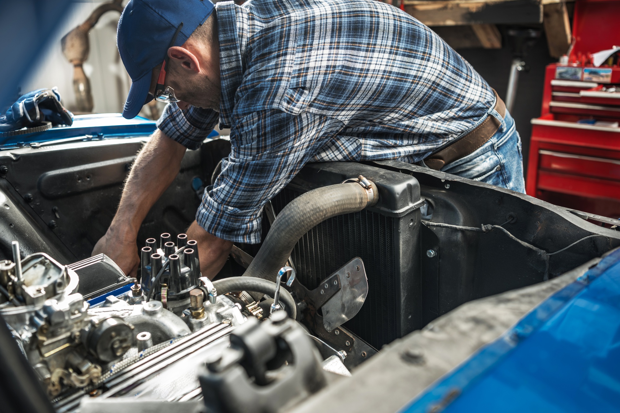 Mechanic Working on Engine in Garage During Daytime